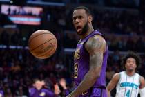 Los Angeles Lakers forward LeBron James, left, yells after dunking as Charlotte Hornets guard D ...