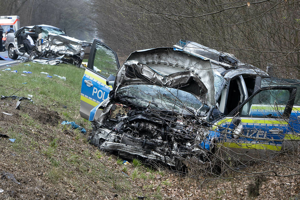 A damaged police car is seen next to a road in Langen near Frankfurt, Germany, Sunday, March 31 ...