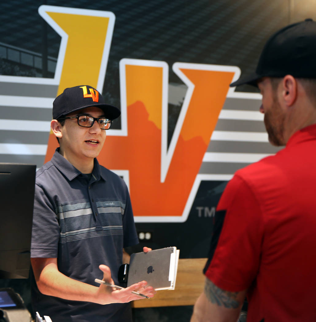 Employee Ian Karate speaks with a customer at the Las Vegas Aviators sales office in Downtown S ...
