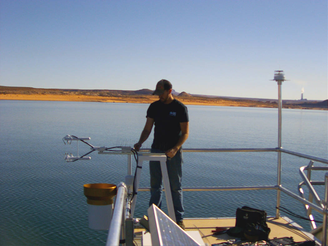 A researcher adjusts equipment during installation of a floating evaporation station at Lake Po ...