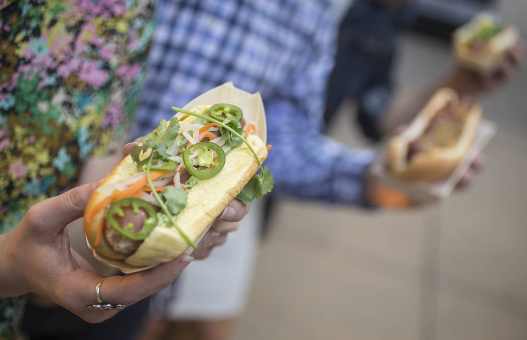 Jessica Legris, left, holds a Jet Setter hotdog at Aviators media day near Las Vegas Ballpark o ...