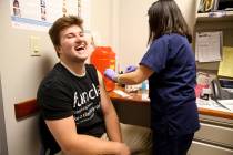 Senior Community Health Nurse Jocelyn Castillo gives Cole Nisson, 18, of Henderson a flu shot a ...
