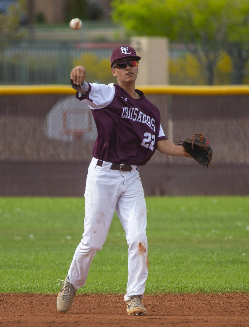 Faith Lutheran's Shane Taylor (22) tosses the ball to first base versus Palo Verde during their ...