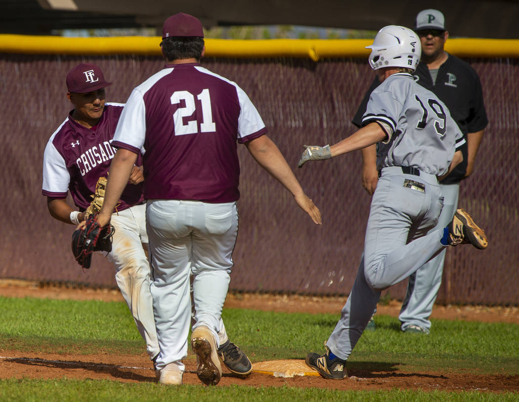 Faith Lutheran's Jacob Ortega (8) gets back to first base for the out before Palo Verde runner ...