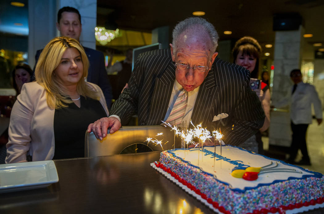 Former Las Vegas Mayor Oscar Goodman attempts to blow out some sparklers atop a congratulations ...