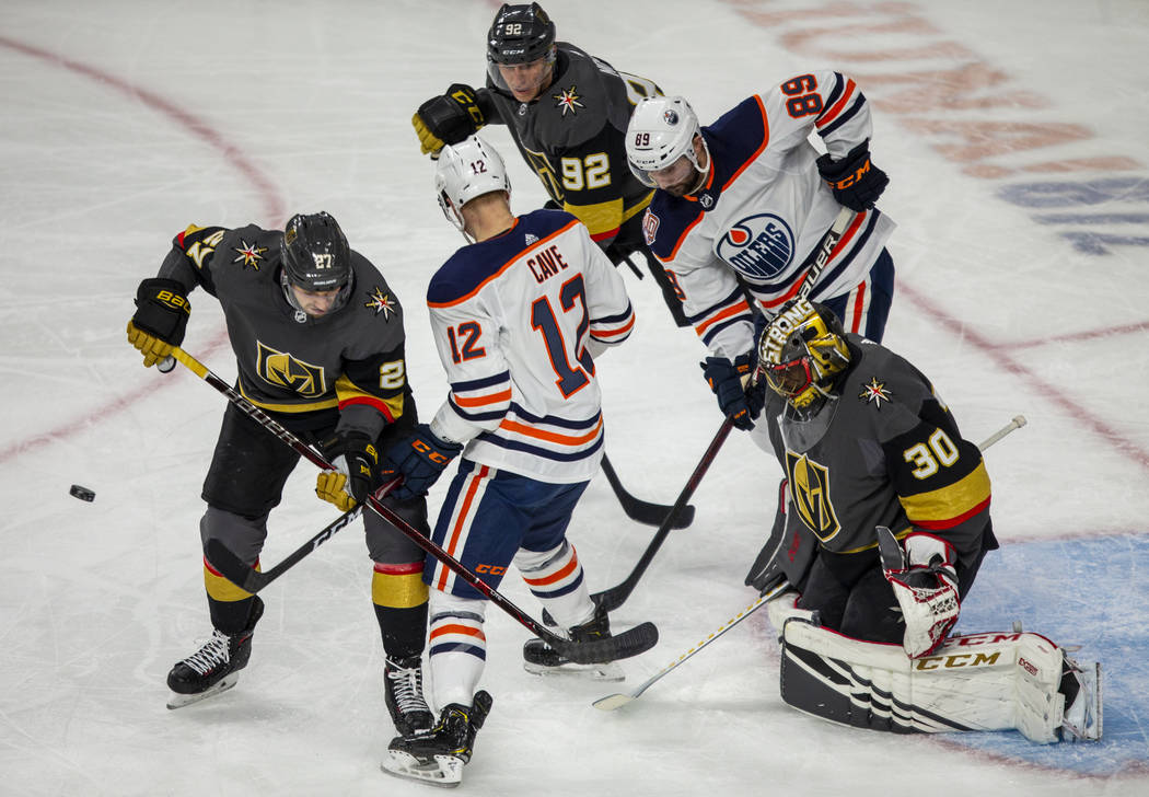 Vegas Golden Knights goaltender Malcolm Subban (30) eyes a loose puck amongst teammates and Edm ...