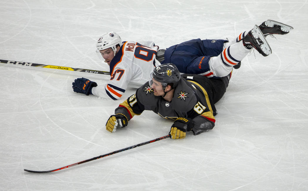 Edmonton Oilers center Connor McDavid (97) lands on top of Vegas Golden Knights right wing Mark ...