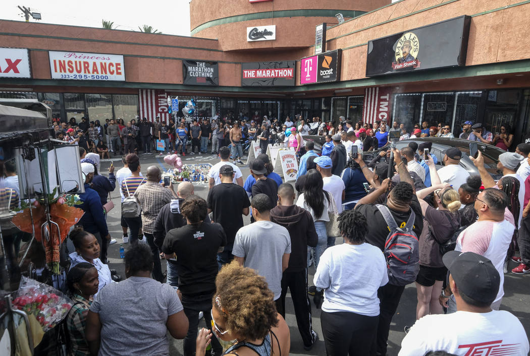 Fans of rapper Nipsey Hussle gather at a makeshift memorial in the parking lot of the Marathon ...