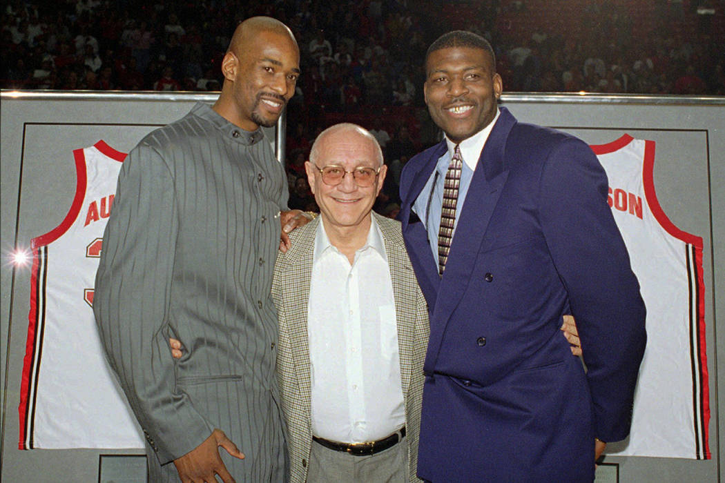 Former UNLV head basketball coach Jerry Tarkanian, center, poses with two of his former star pl ...