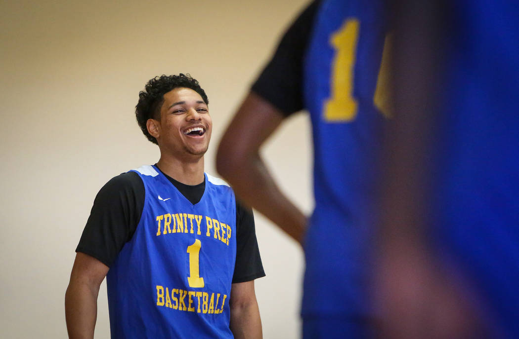 Trinity International junior Daishen Nix laughs while talking with his teammates during a pract ...