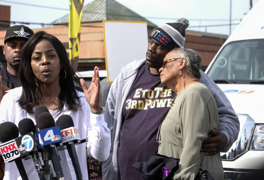Marcus Woods, second from right, comforts Lita Herron, right, as Denise Francis Woods, second f ...