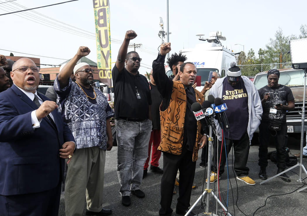 Project Islamic Hope CEO Najee Ali, at microphones, join other community activists at a news co ...