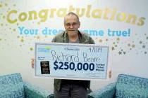 Richard Beare holds a large check after winning $250,000 in the North Carolina Education Lotter ...