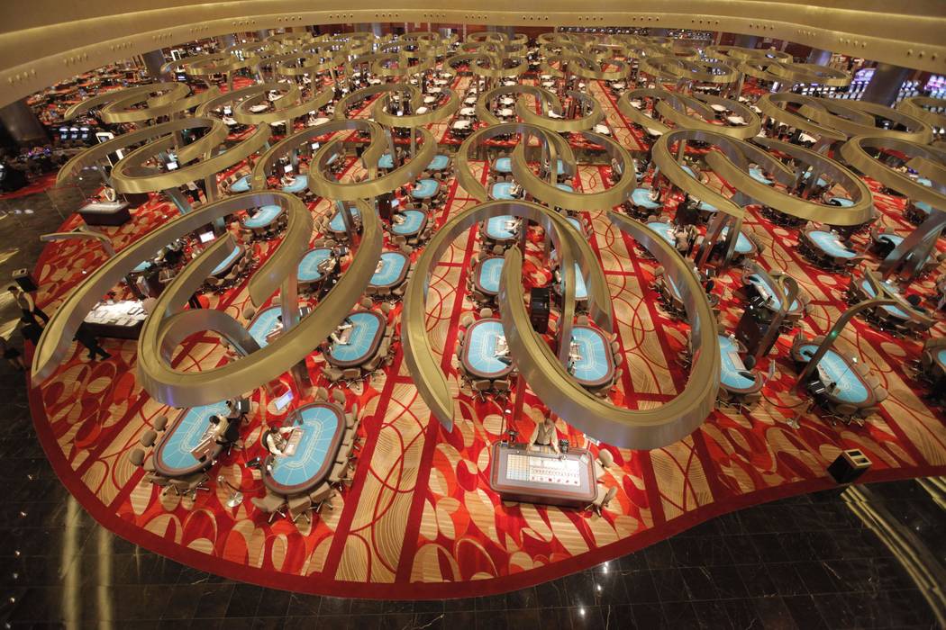 Game dealers wait at tables of the casino at Marina Bay Sands, April 27, 2010, in Singapore. La ...