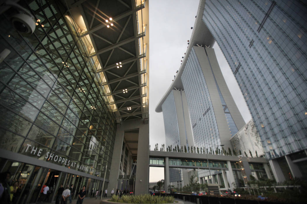 People walk near the facade of the Marina Bay Sands integrated resort, June 23, 2010. (Wong Ma ...