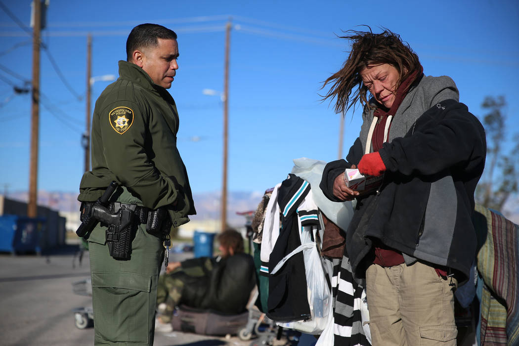 Las Vegas police officer Angel Nunez speaks with homeless woman Shannon Hennessy about services ...