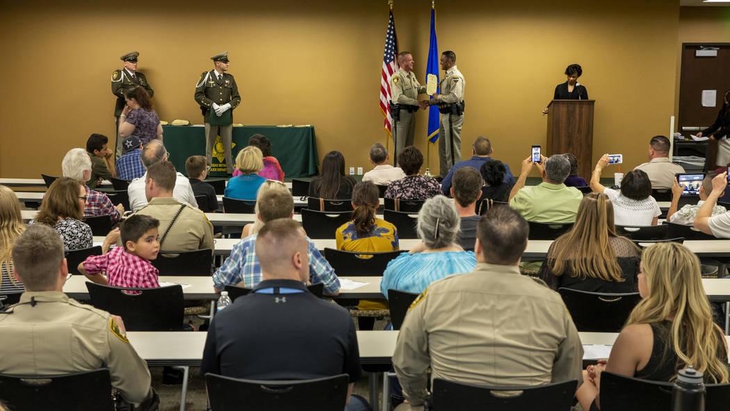 Undersheriff Kevin McMahill presents officer Rolando Pro with a lifesaving award during a Metro ...