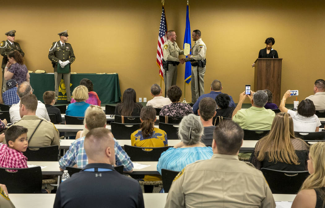 Undersheriff Kevin McMahill presents officer Rolando Pro with a lifesaving award during a Metro ...