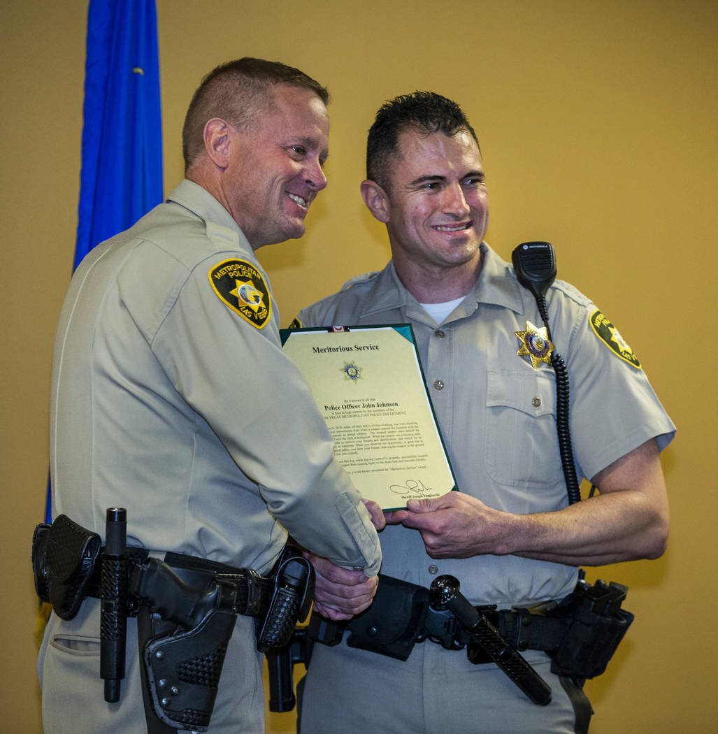 Undersheriff Kevin McMahill presents Detective John Johnson with a meritorious award during a M ...