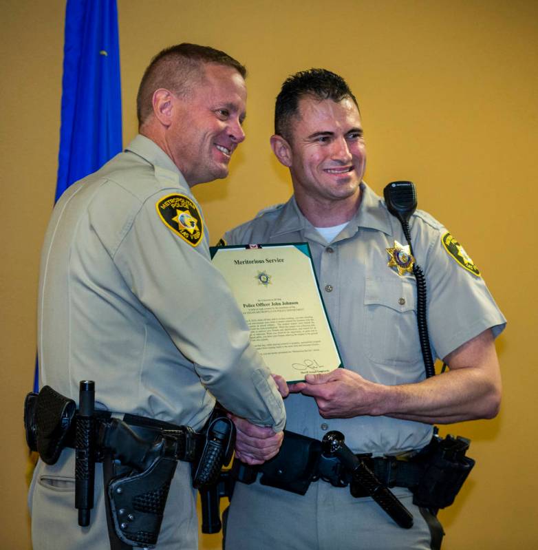 Undersheriff Kevin McMahill presents Detective John Johnson with a meritorious award during a M ...