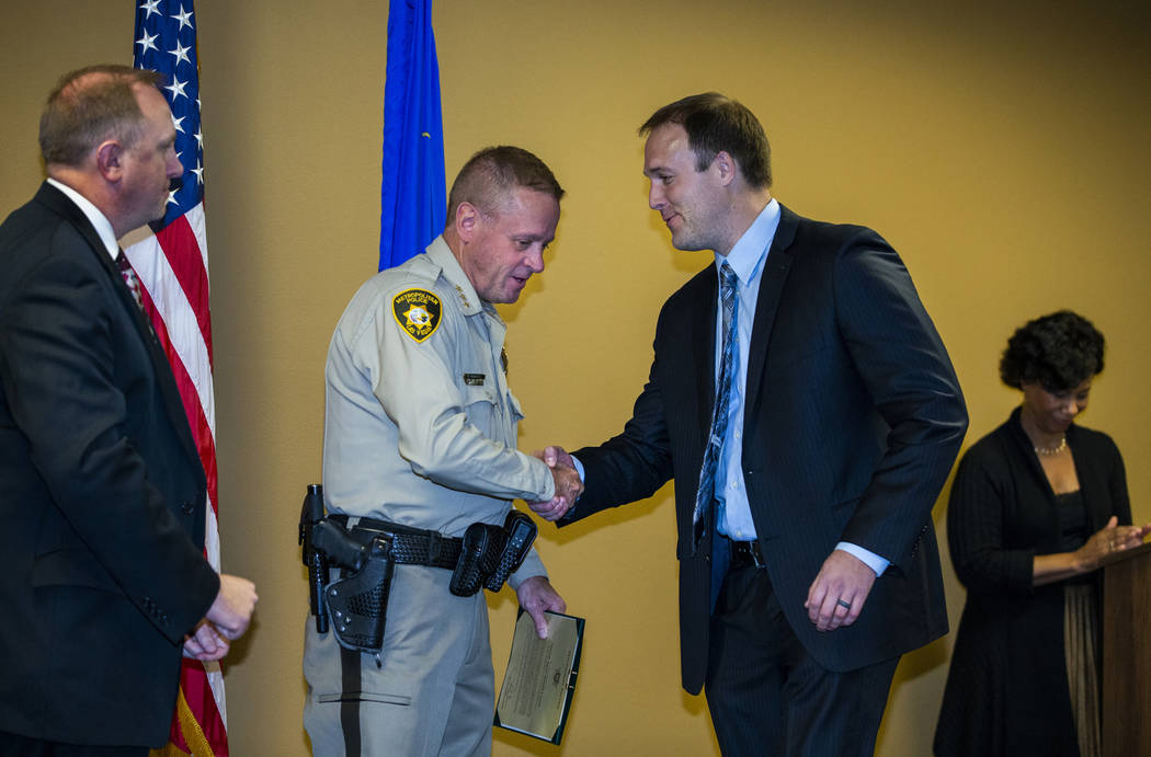 Undersheriff Kevin McMahill presents FBI Special Agent Daniel Coxon with a meritorious award du ...