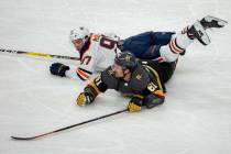 Edmonton Oilers center Connor McDavid (97) lands on top of Vegas Golden Knights right wing Mark ...