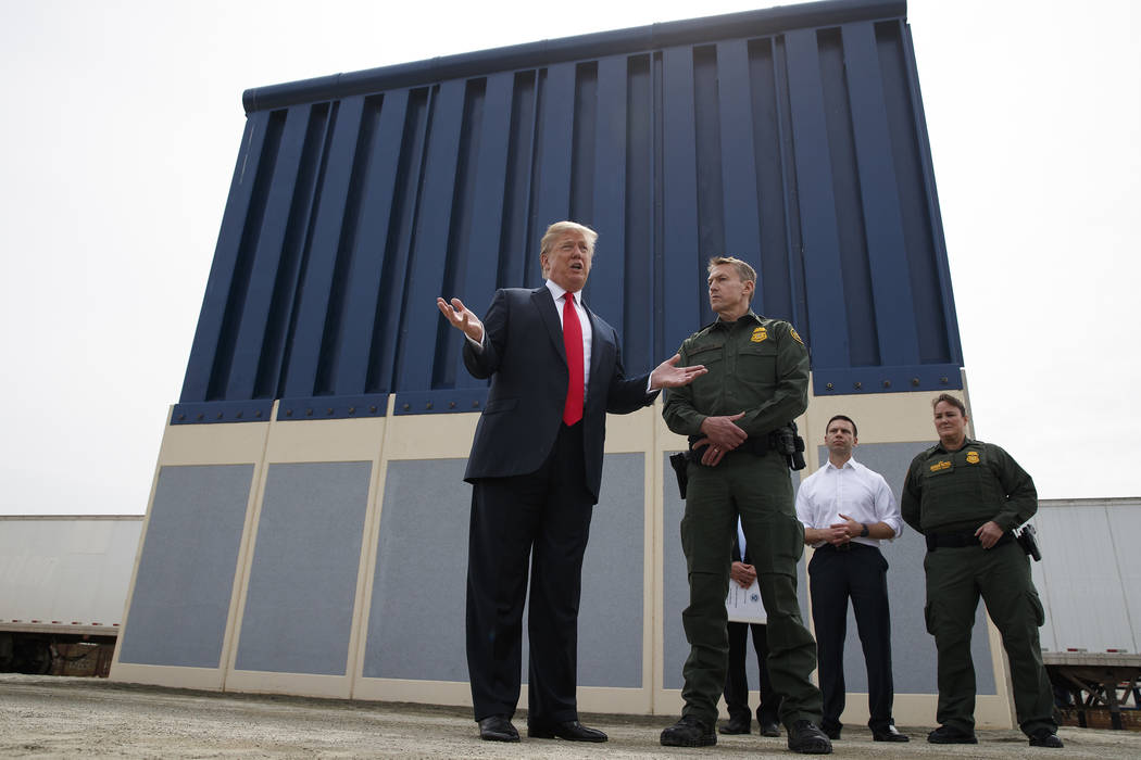 President Donald Trump talks with reporters as he reviews border wall prototypes in San Diego i ...