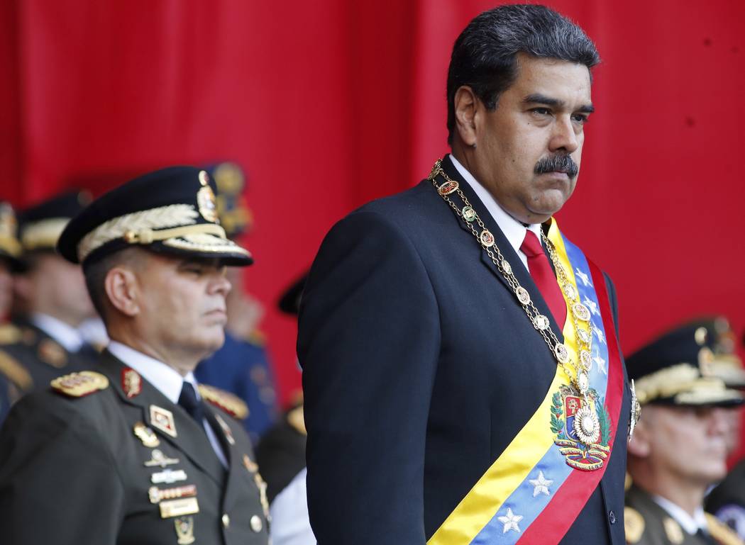 Venezuela President Nicolas Maduro watches a military parade, alongside his Defense Minister Vl ...