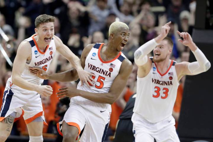 Virginia's Mamadi Diakite, center, reacts with teammates Kyle Guy and Jack Salt (33) after hitt ...