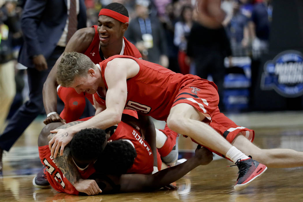 Texas Tech players, including Norense Odiase, bottom left, Brandone Francis, bottom right, and ...