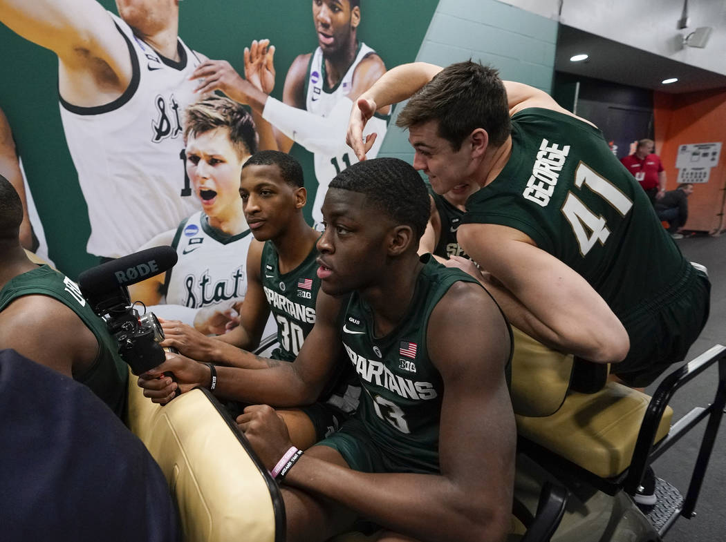 Michigan State's Gabe Brown, Marcus Bingham Jr. and Conner George gets a ride after a practice ...