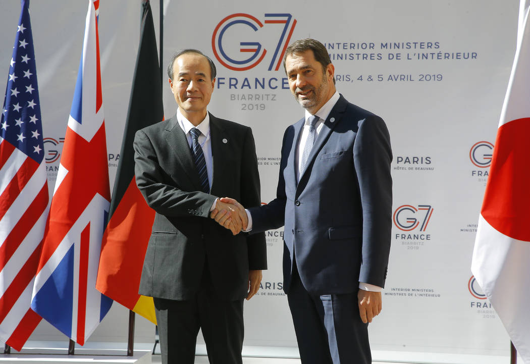 Japan's Deputy Commissisioner General Mitsuhiro Matsumoto, left, is welcomed by French Interior ...