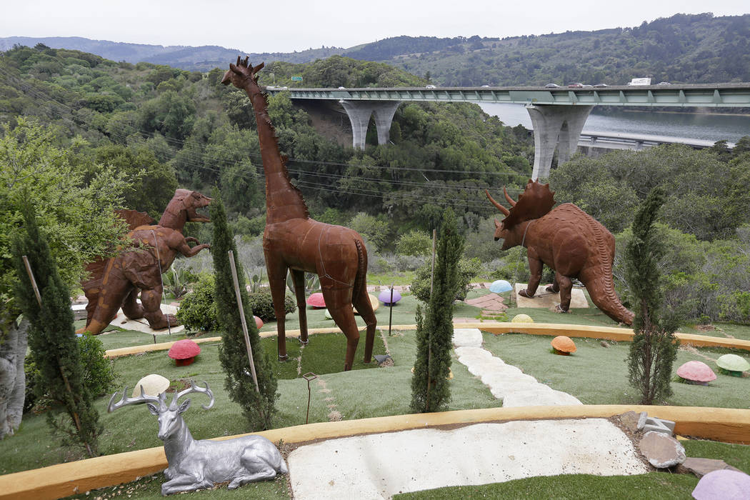 In this photo taken Monday, April 1, 2019, dinosaurs and other figures stand outside the Flints ...