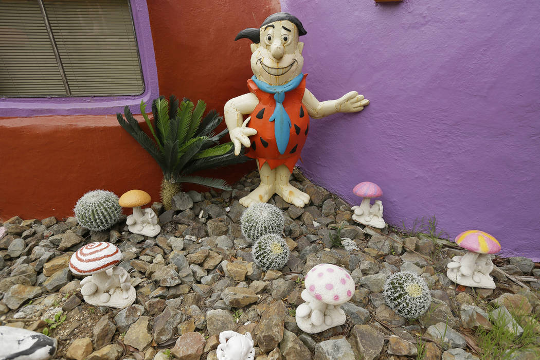 In this photo taken Monday, April 1, 2019, are figurines of Fred Flintstone standing among mush ...