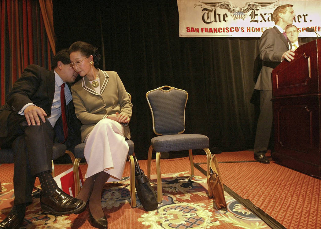 In this Feb. 19, 2004, photo, James Fang, left, talks with his mother, Florence Fang, as presid ...