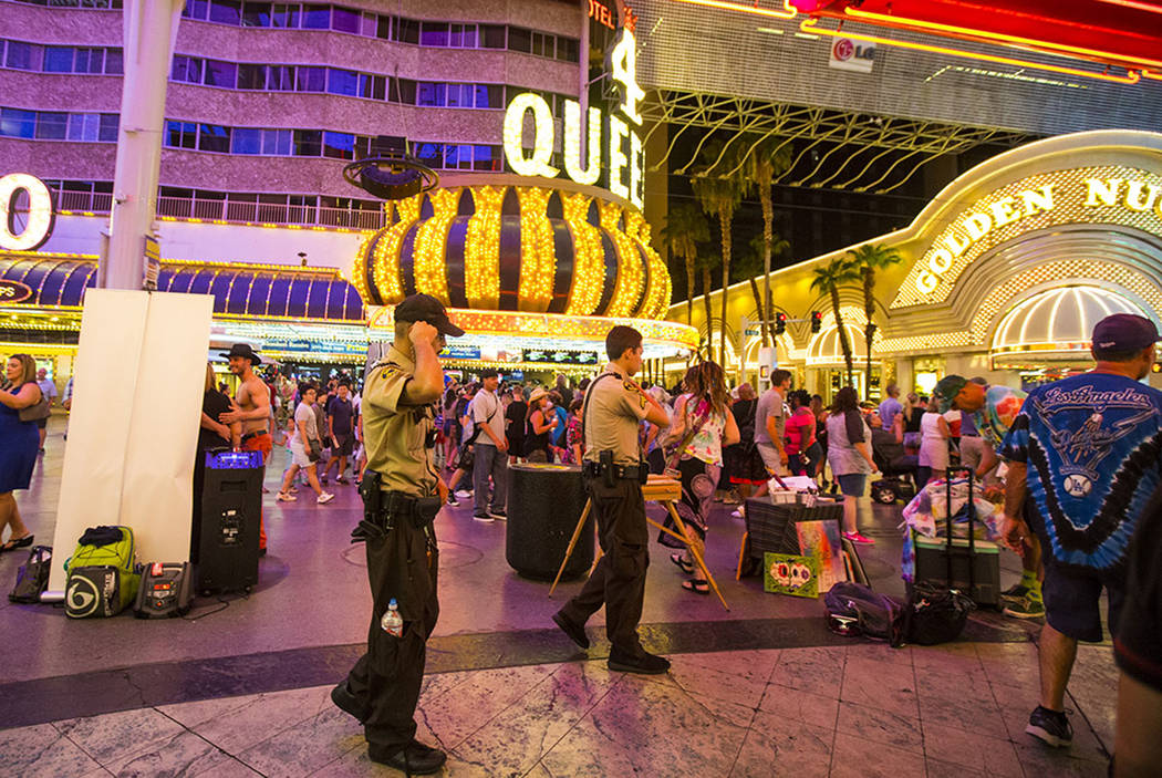 Security officers patrol along the Fremont Street Experience in downtown Las Vegas on Thursday, ...