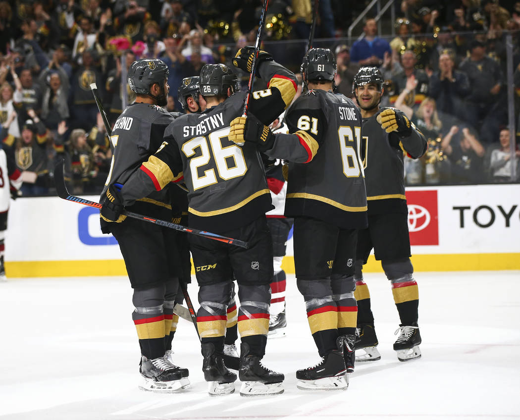 Golden Knights players celebrate a goal by Mark Stone (61) during the first period of an NHL ho ...