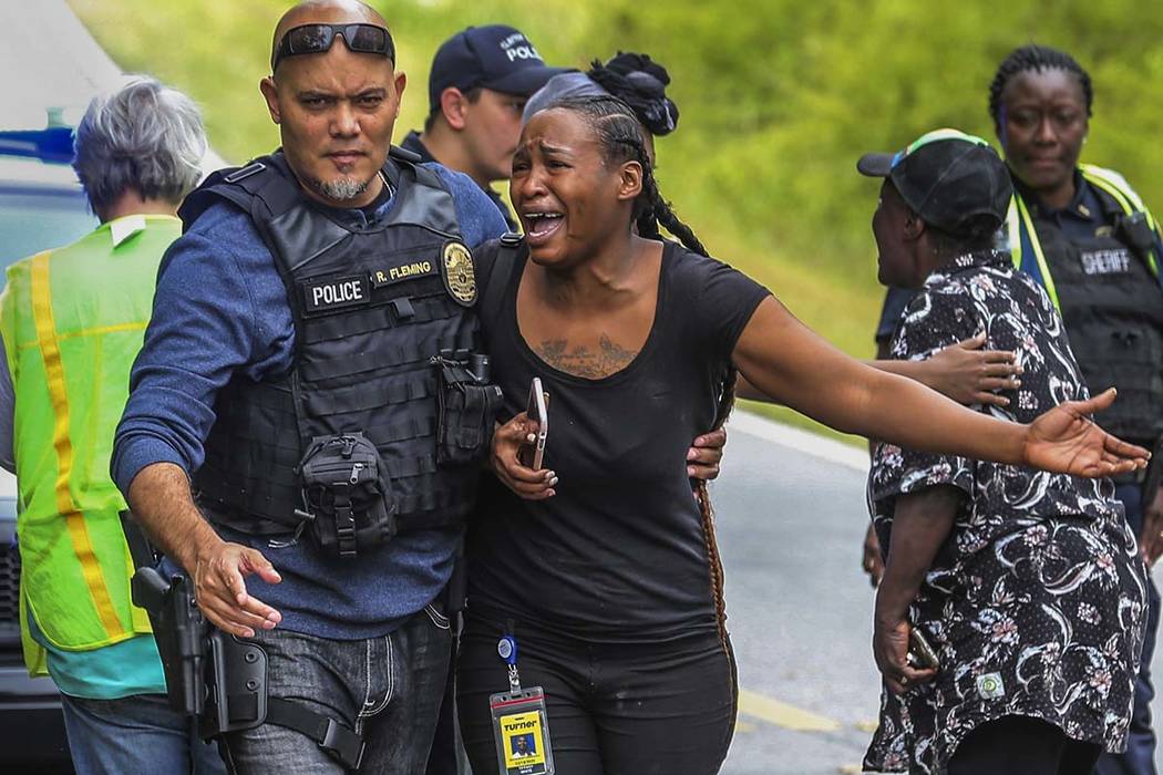 A woman believed to be related to ones involved in a hostage situation reacts as law enforcemen ...