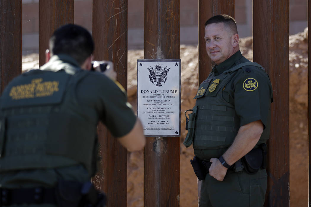 Border Patrol agent Michael Sullivan, right, poses Oct. 26, 2018, for a picture next to a plaqu ...