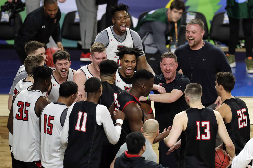 Texas Tech head coach Chris Beard laughs with his players in a huddle during a practice session ...