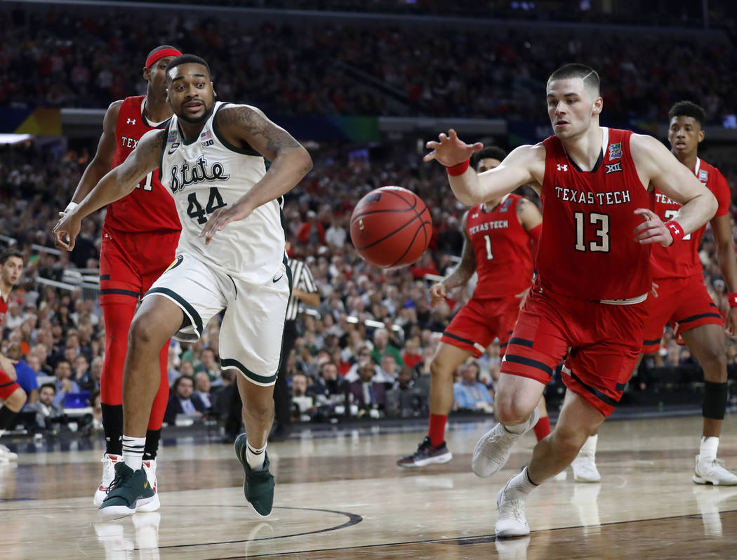 Texas Tech's Matt Mooney (13) chases a loose ball against Michigan State's Nick Ward (44) durin ...