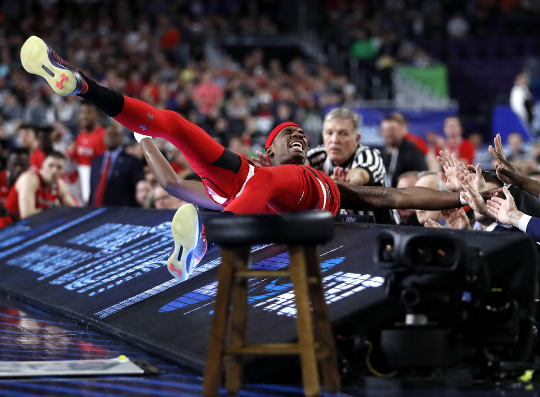 Texas Tech forward Tariq Owens lands on the scorers table while trying to save a ball from goin ...