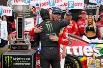 Kyle Busch, facing camera, gets a hug from brother Kurt Busch after winning the NASCAR Cup Seri ...