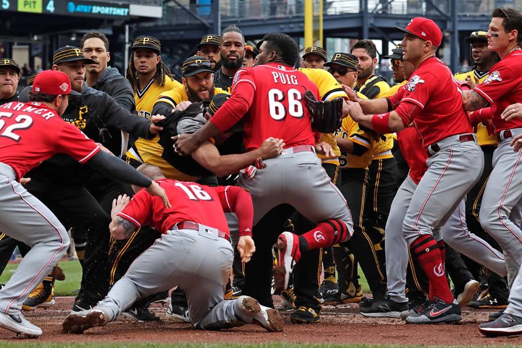 Cincinnati Reds' Yasiel Puig (66) pulls away from Tucker Barnhart (16) as he attempts to re-ent ...
