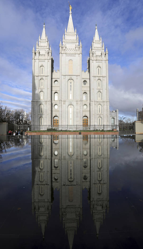 The Salt Lake City temple is reflected in a pool during The Church of Jesus Christ of Latter-da ...