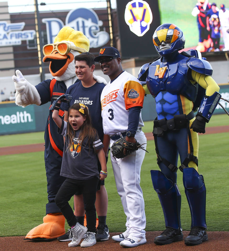 Nine-year-old Hailey Dawson, center, poses after throwing the first pitch with, from left, Spru ...