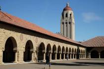 FILE- In this March 14, 2019, file photo, people walk on the Stanford University campus beneath ...