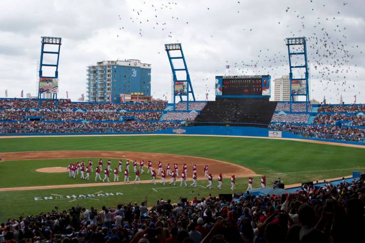 The Cuban national baseball team walks off the field as birds are released, at the start of the ...