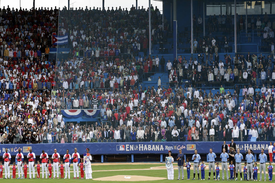 Tampa Bay Rays and the Cuban National team stand as the national anthems are played before thei ...