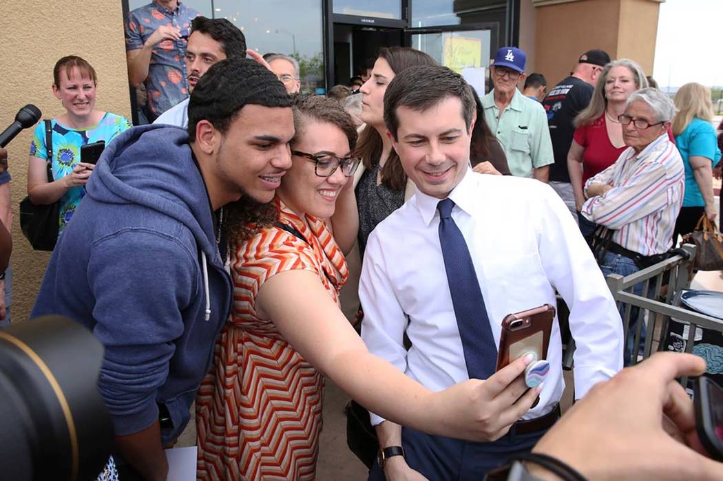 Indiana's South Bend Mayor Pete Buttigieg, right, poses for a selfie with Cameron Mitchell and ...